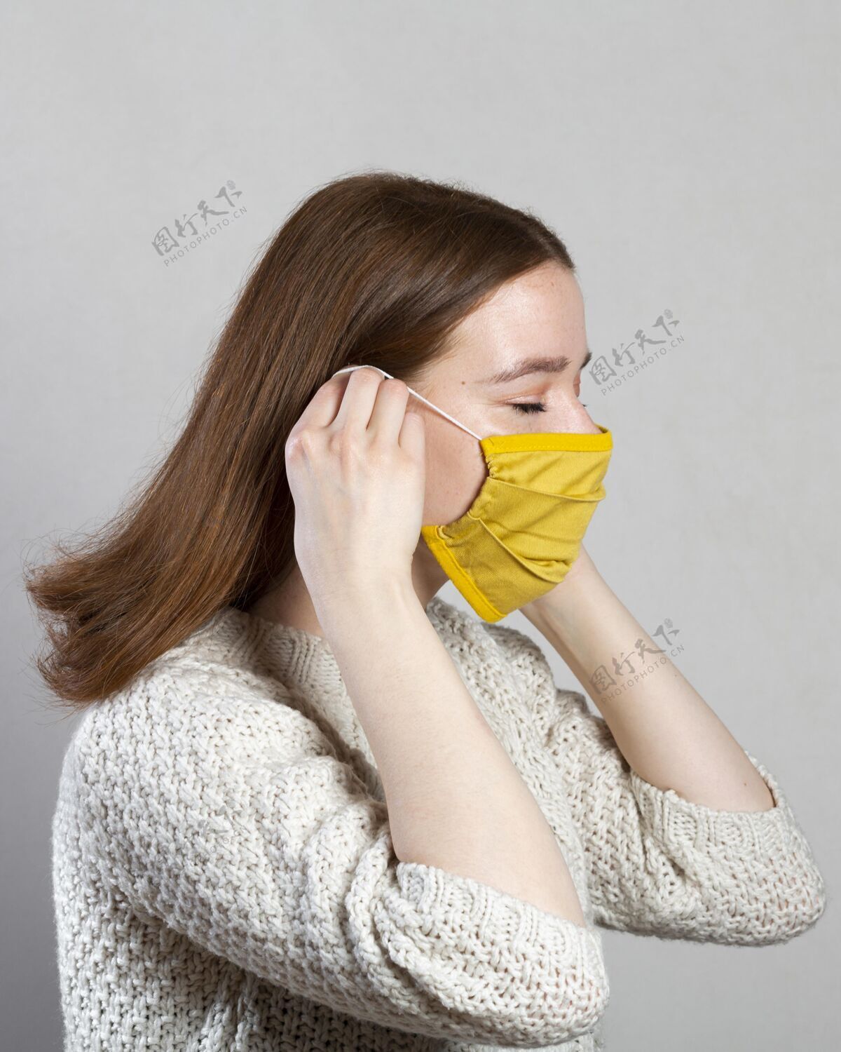 病毒一个试图戴上医用面罩的女人的侧视图面罩预防预防