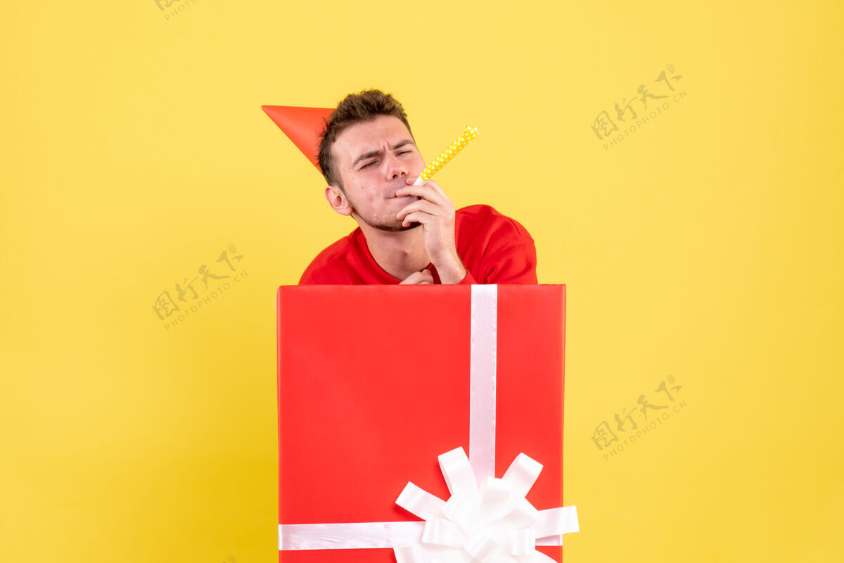 雪正面图穿红衬衫的年轻男子坐在礼品盒内年轻红色人
