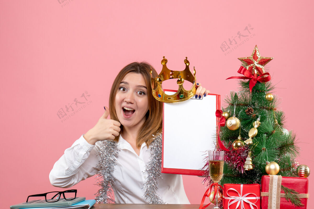 圣诞节戴着皇冠的女工正面图和粉红色的锉刀笔记礼物人