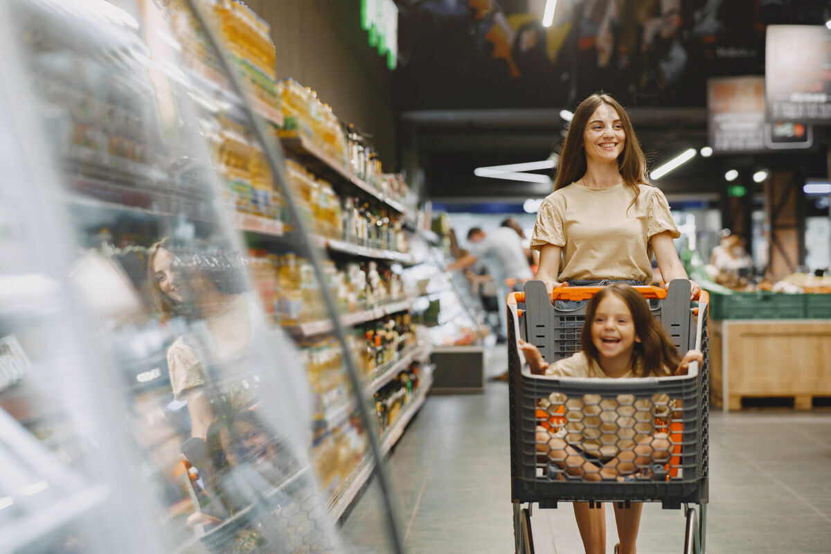 购买一家人在超市一个穿棕色t恤的女人人们选择产品母亲带着女儿成人购物零售