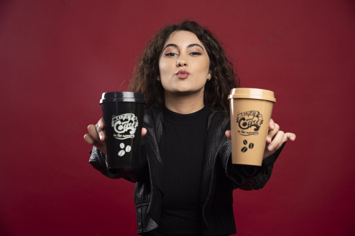 模特一个穿全黑衣服的年轻女人 展示着两个杯子魅力咖啡漂亮