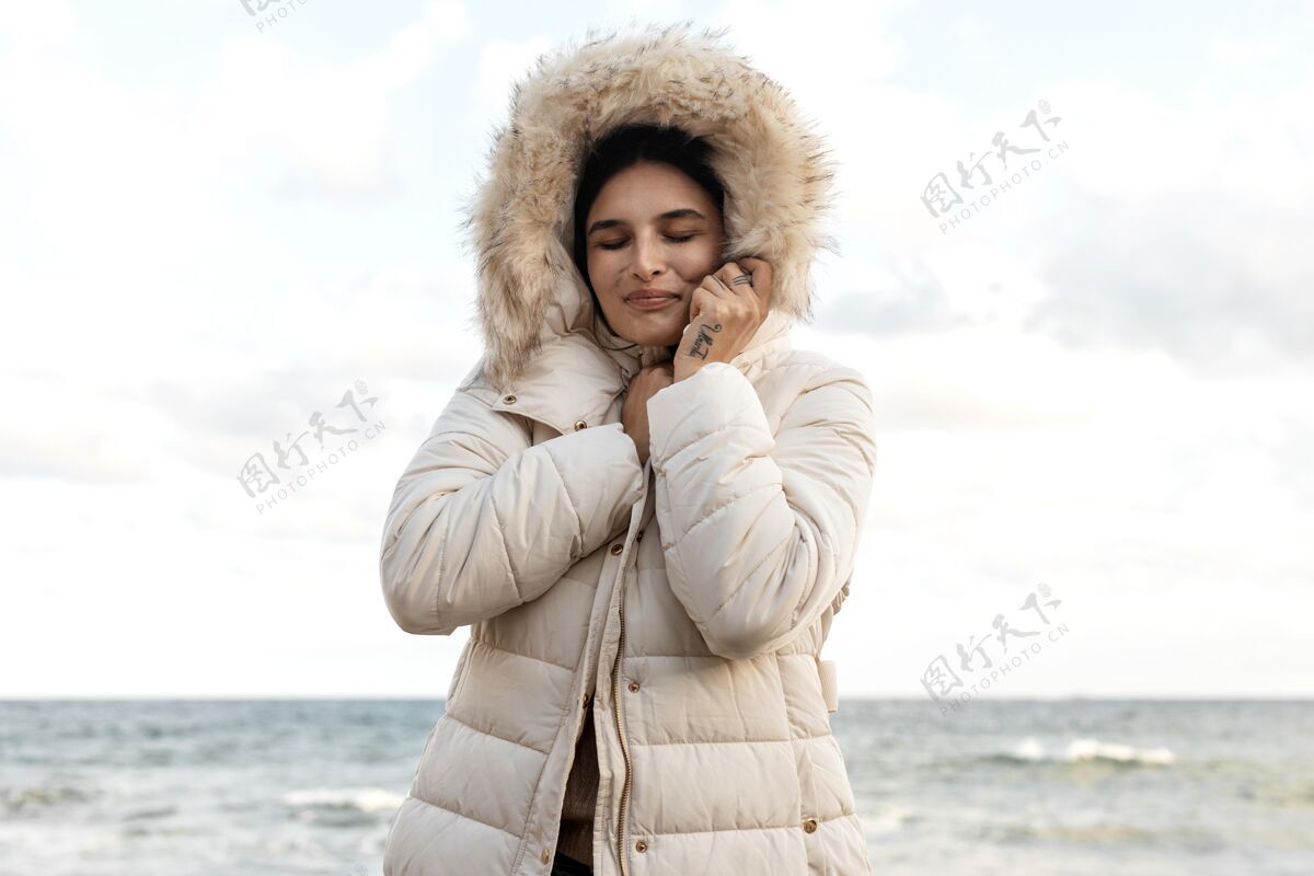 航行海滩上穿着冬装的笑脸女人旅行公路远足