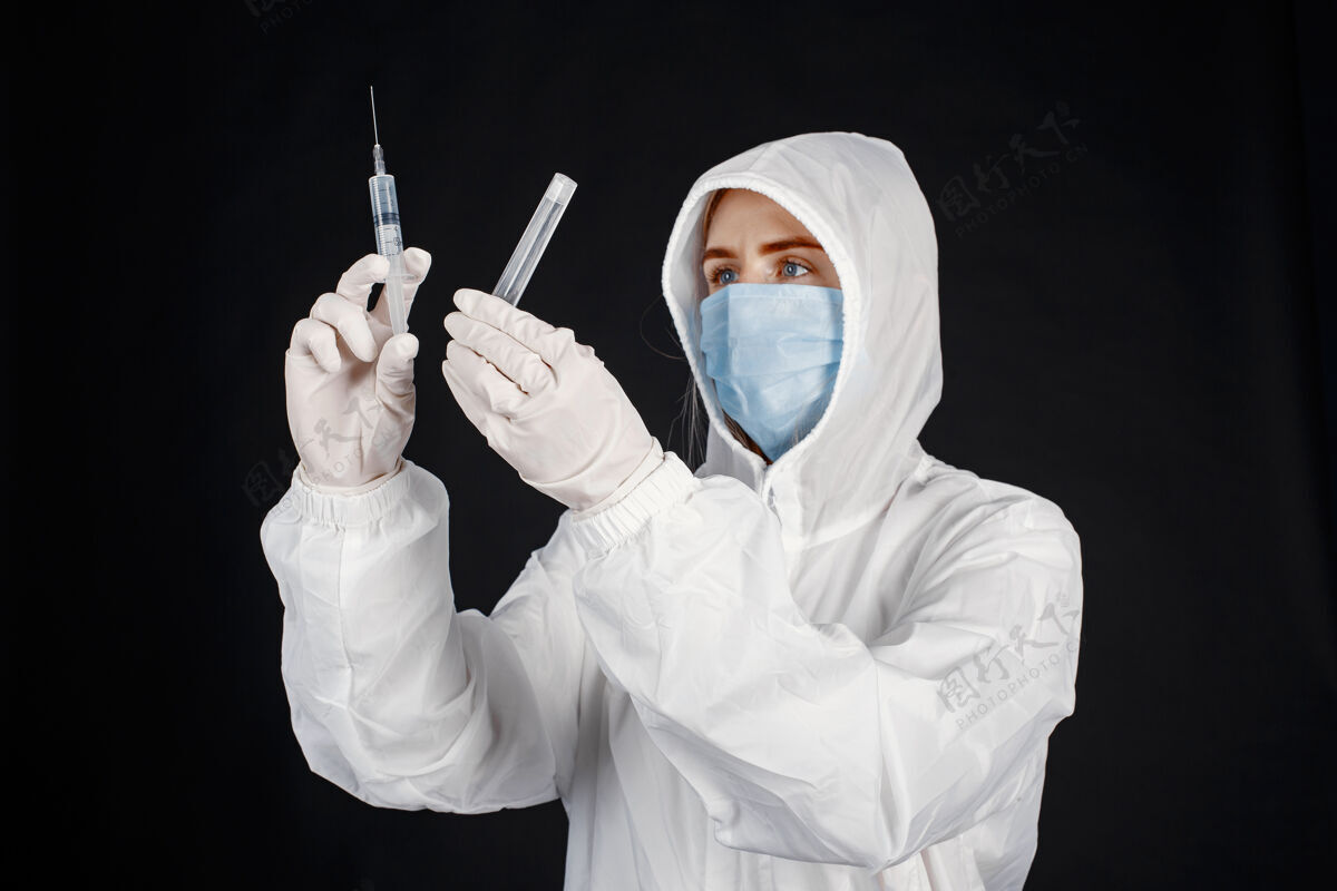 临床戴着医用面罩的医生冠状病毒隔离在黑墙上穿着防护服的女人从业者制服工作