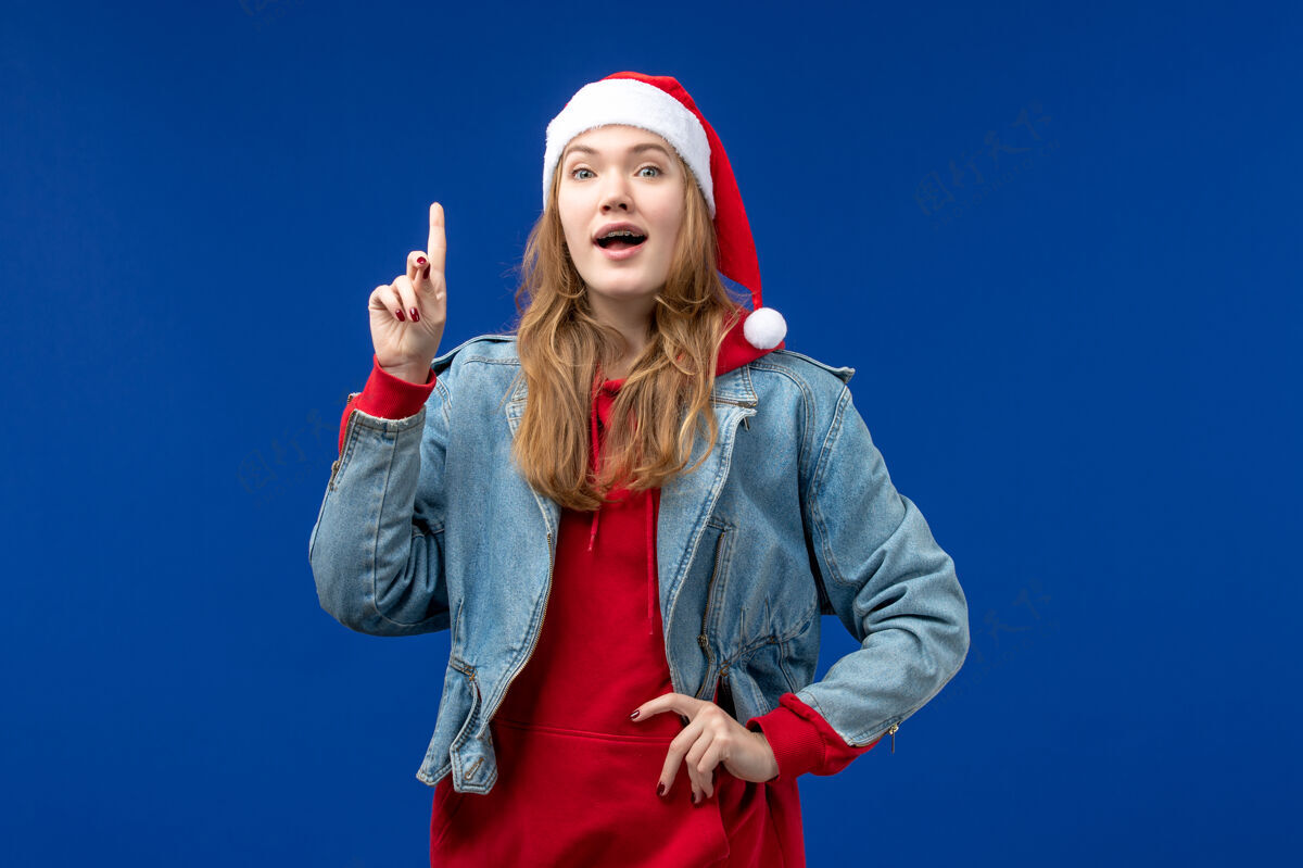 工作室蓝色背景上的年轻女性在新年假期圣诞节前的兴奋表情人物成人快乐