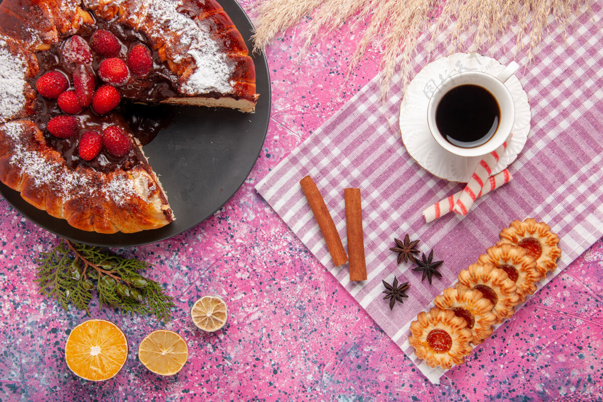 铅笔俯瞰美味的巧克力蛋糕配饼干和一杯茶在浅粉色的桌子上饼干甜甜的甜点蛋糕烤馅饼烘焙茶甜点