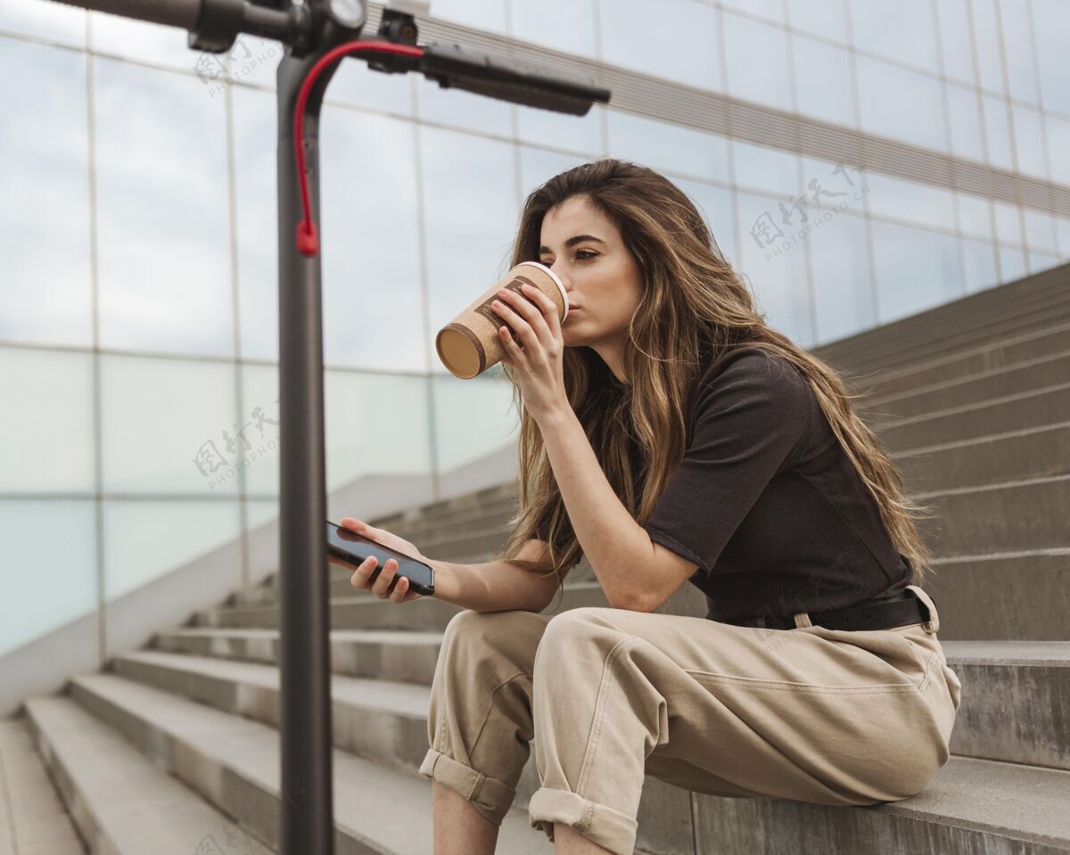 城市正在喝咖啡的年轻女人生活方式城市交通Escooter