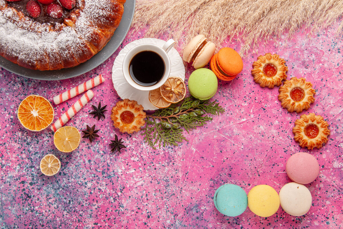 饼干顶视图一杯茶 粉红色桌子上放着饼干和麦卡龙 烤蛋糕 饼干 甜甜的糖香料顶部烘焙