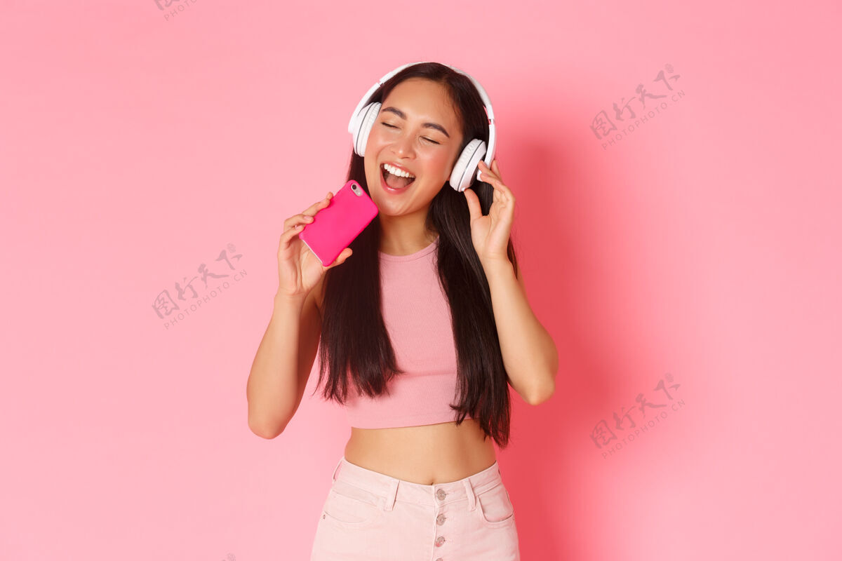 耳机一个戴着耳机听音乐的富有表情的年轻女子亚洲现代舞蹈
