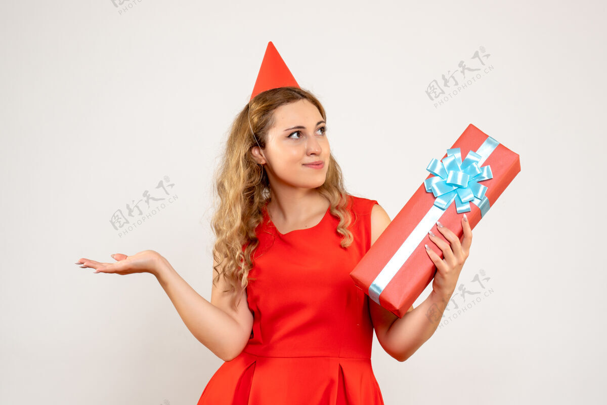 圣诞正面图身着红色连衣裙的年轻女性用礼物庆祝圣诞节幸福庆祝颜色