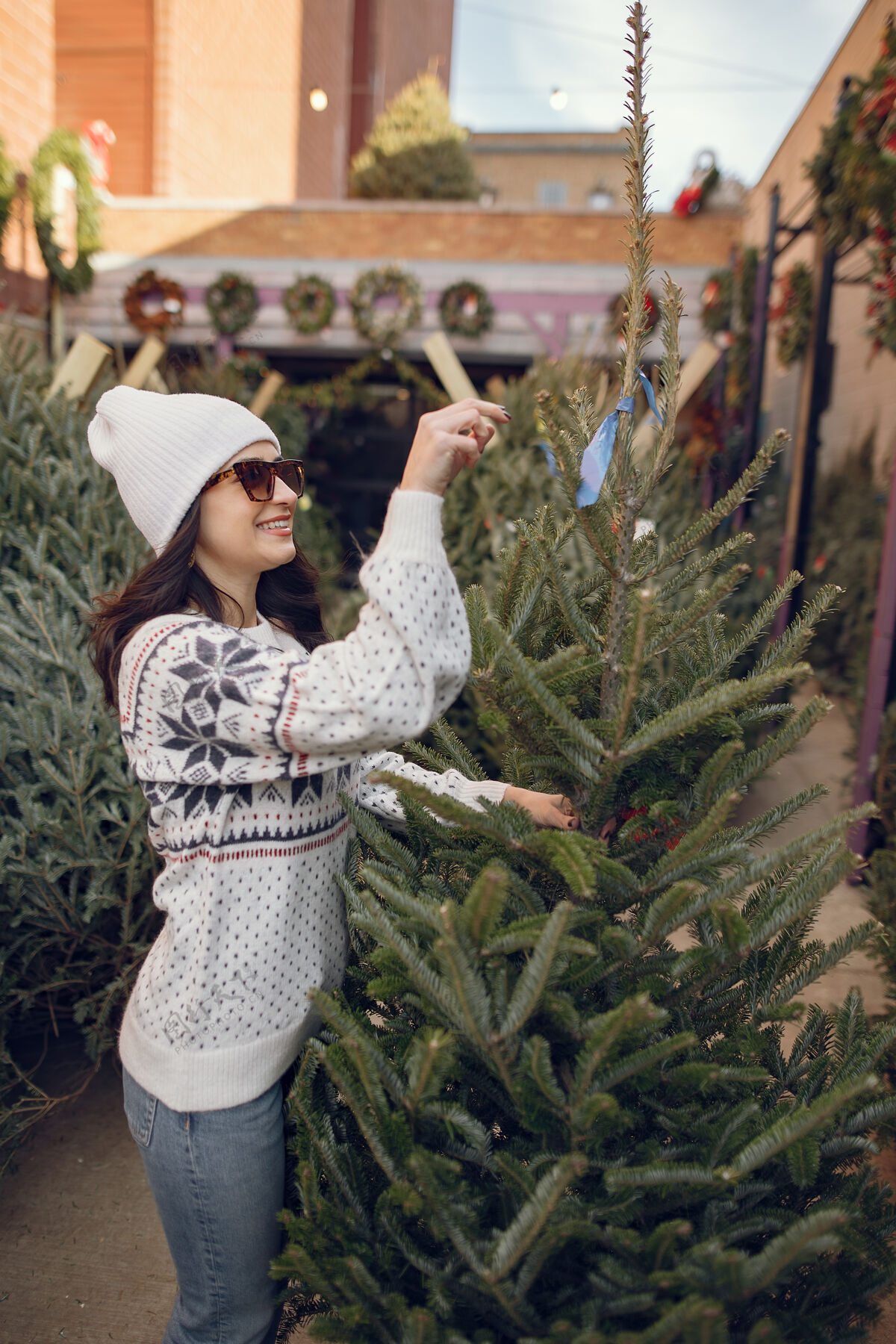 快乐优雅的女孩买了一棵圣诞树自然销售卷发