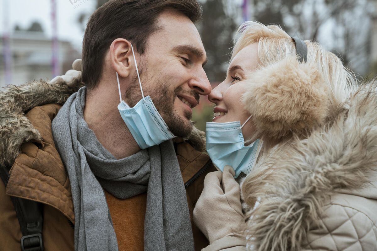 女人冬天的情侣戴着医用口罩年轻关系冬天的衣服