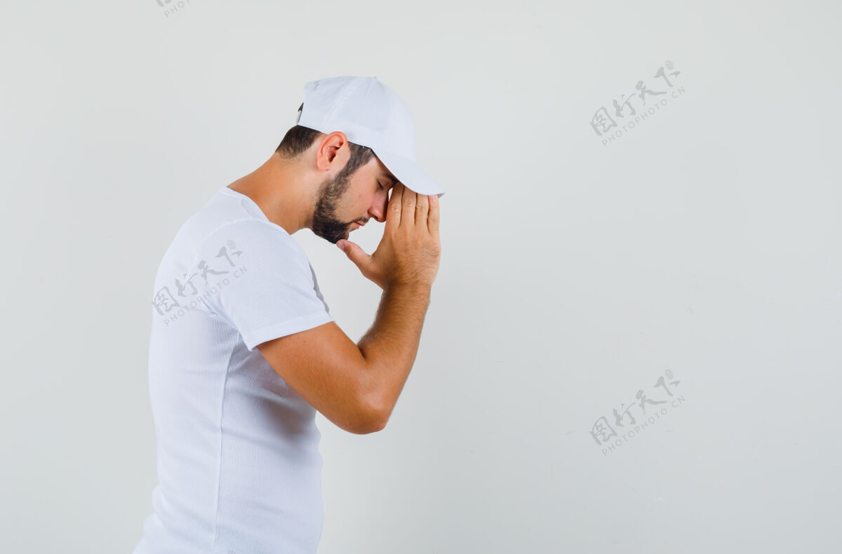衬衫一个年轻人穿着t恤展示祈祷的姿势 看起来充满了希望……空间里有文字帽子手势成人