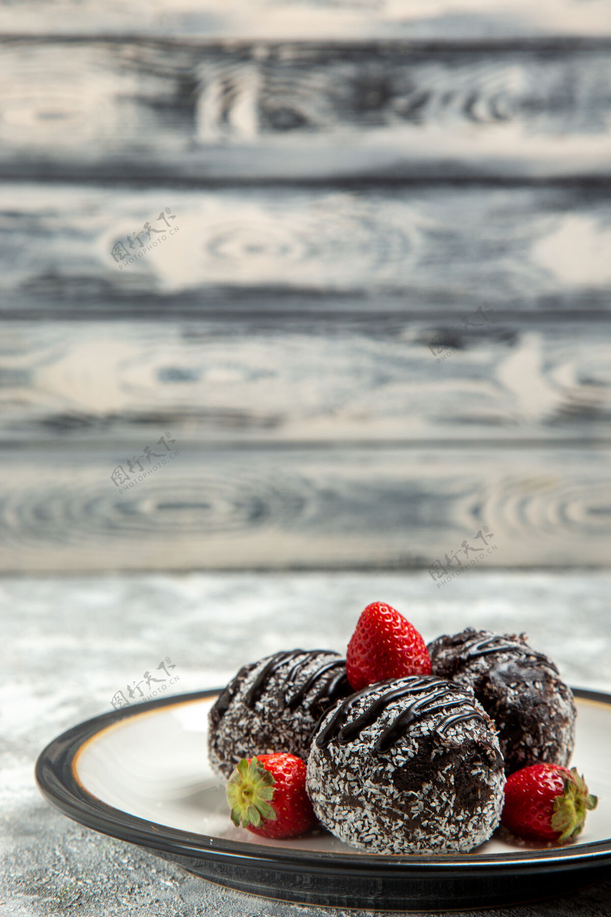 饼干正面图美味的巧克力蛋糕和红草莓在浅白的墙上巧克力糖饼干甜蛋糕烤饼干水果生的可食用的水果