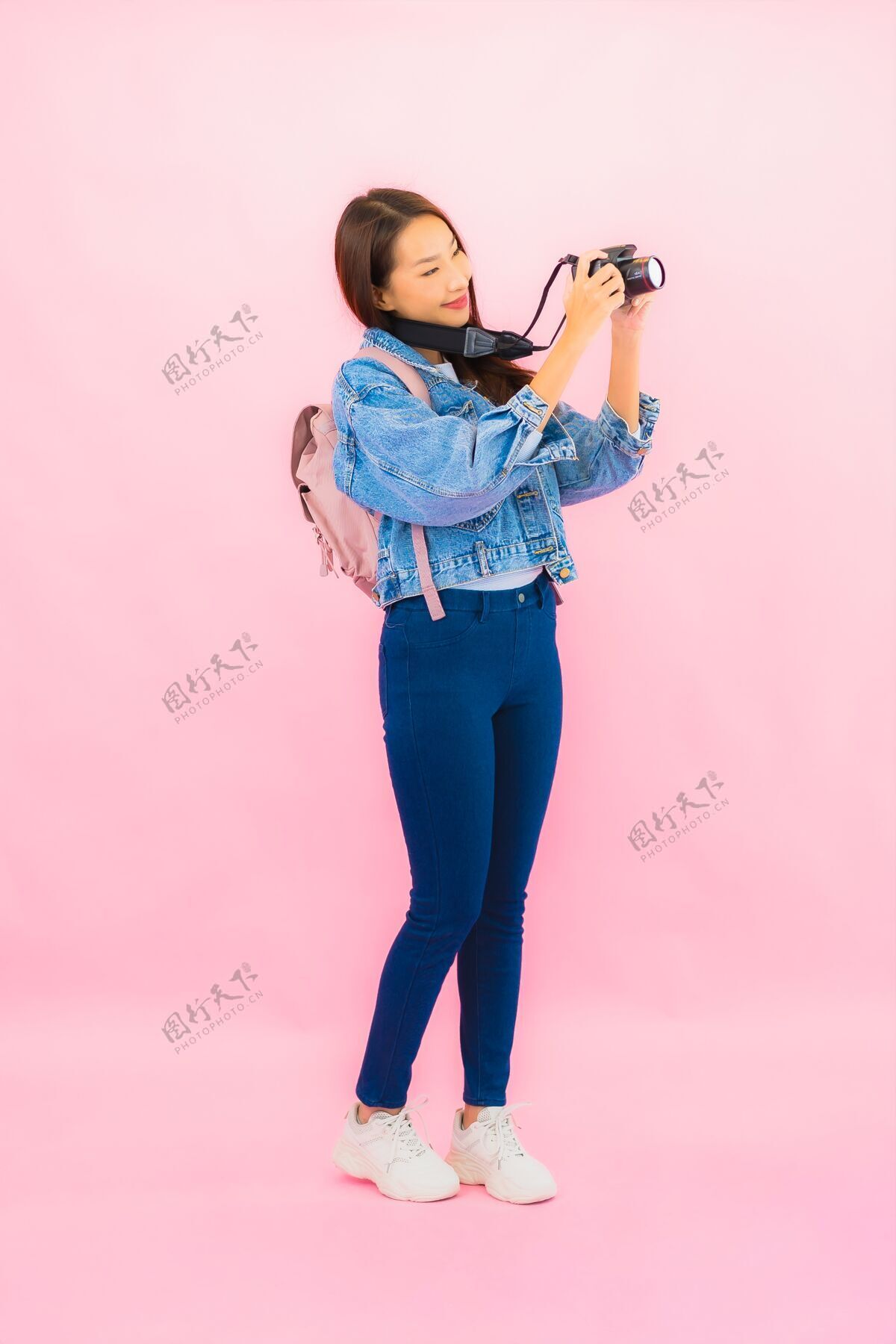 成人肖像美丽的亚洲年轻女子背包或带相机的行李准备在粉红色的墙上度假旅行年轻控制帽子