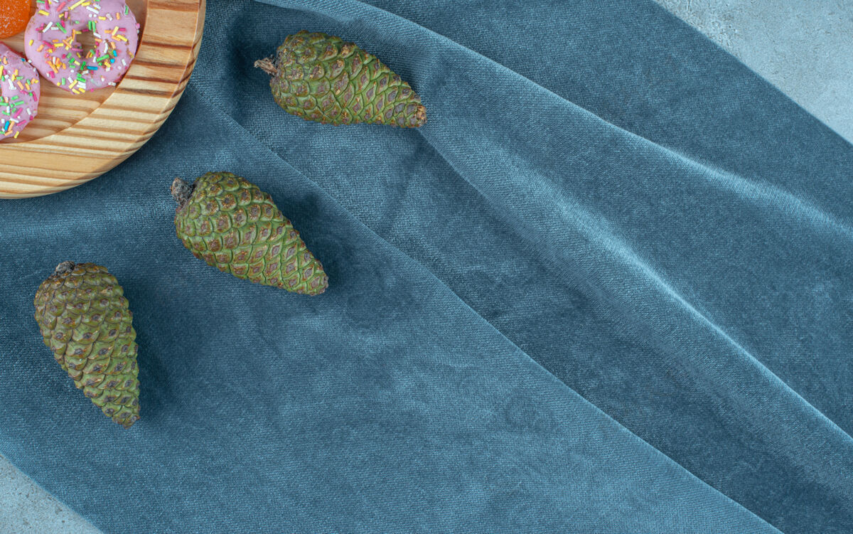 糖松果和一盘甜甜圈在纺织品上松树烘焙Marmelade