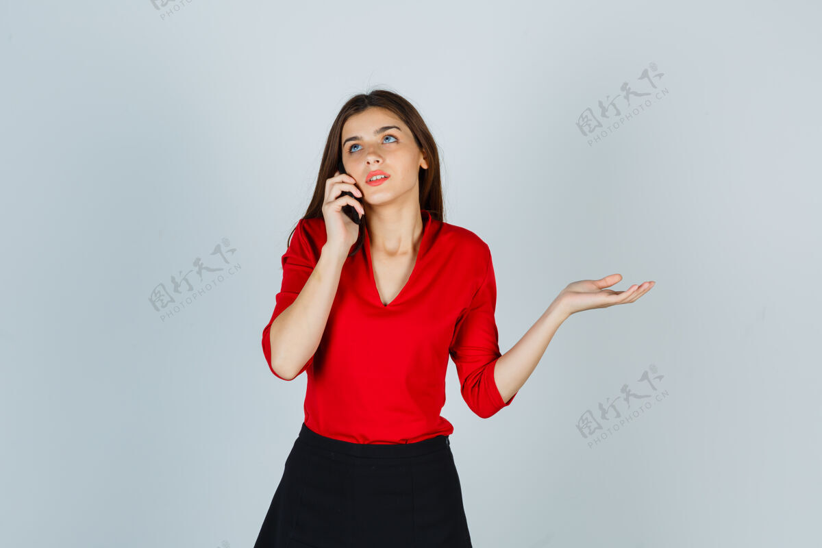 美丽穿着红衬衫 裙子 正在打电话的年轻女士看起来很体贴漂亮问题沉思