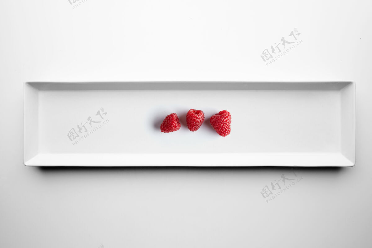 樱桃三个树莓被隔离在白色陶瓷板上菜肴素食主义者早餐