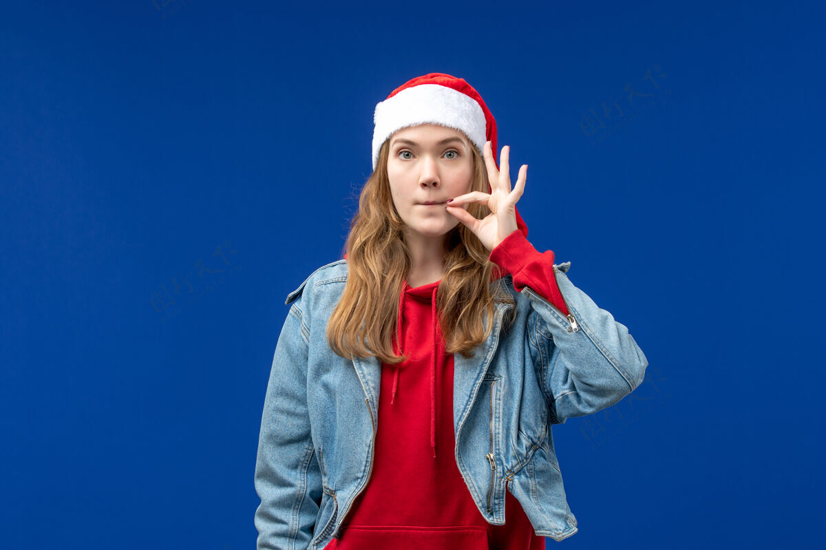 微笑前视图年轻女性闭上嘴蓝色背景圣诞情感色彩背景圣诞节成人