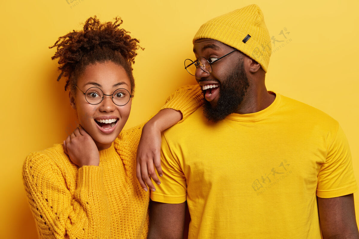肩膀照片中快乐的非洲女孩斜靠在男友的肩膀上 感到快乐 站得很近 表达积极的情绪非洲帽子眼镜
