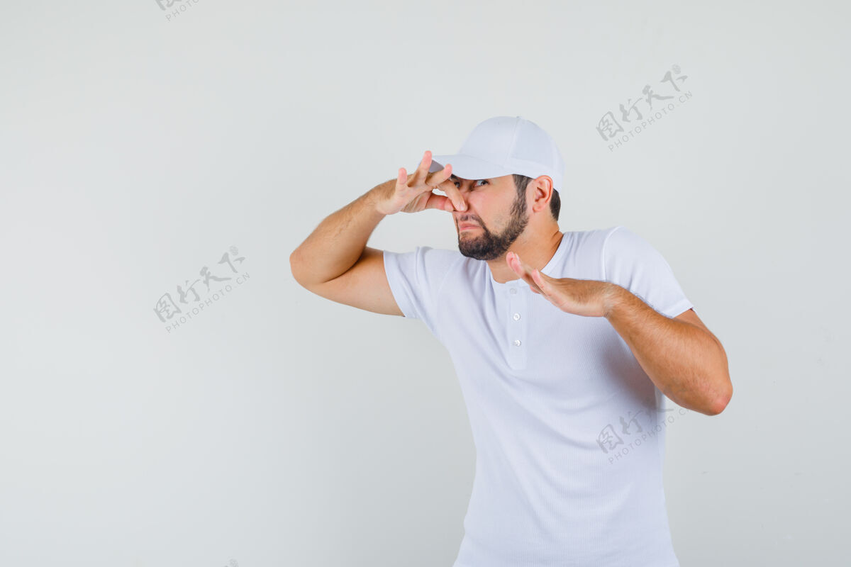 休闲一个穿着t恤 戴着帽子的年轻人流着鼻涕 看上去很恶心 正对着窗外男士成人开朗