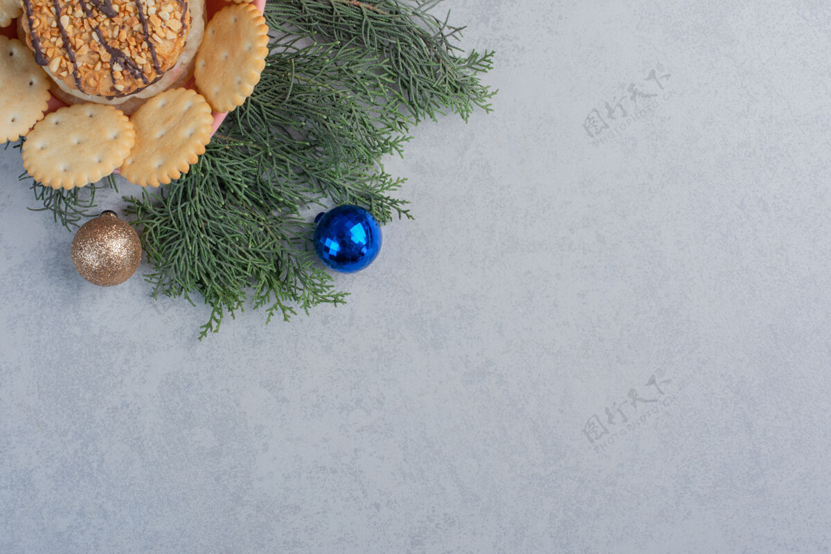 曲奇放在碗里的饼干和饼干在大理石表面的圣诞装饰中树枝美味可口