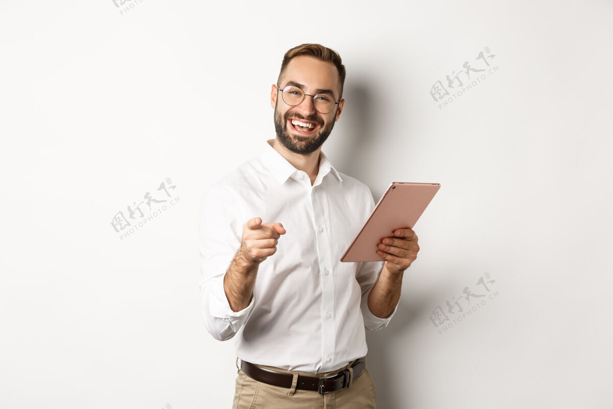 使用快乐而满意的老板称赞工作出色 在数码平板电脑上看书 指着你的相机 站着办公室男人应用程序