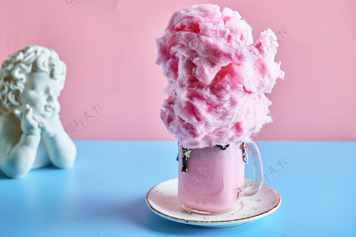 小雕像奶昔和泡泡糖在陶瓷盘子里粉色天使饮料