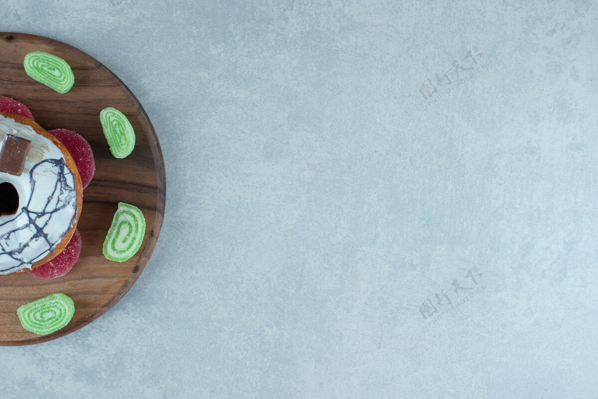 上釉在大理石上的木板上放一个马梅莱斯和一个甜甜圈甜点甜点顶部