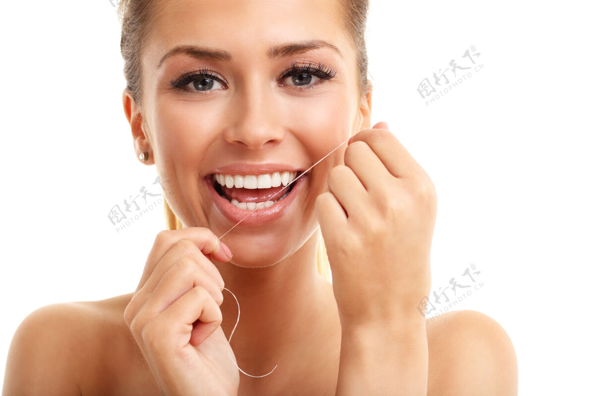 脸一个用牙线洁牙的成年女人牙线健康手