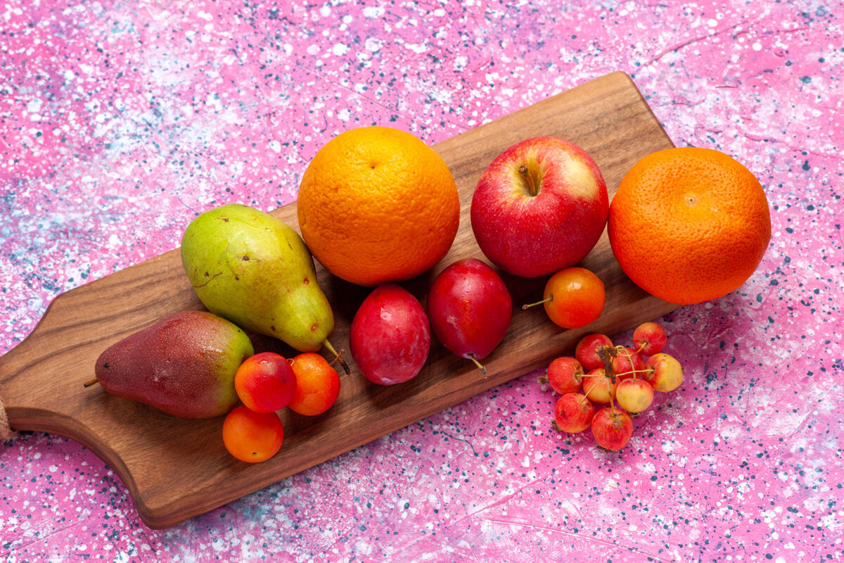 柑橘从粉红色的桌子上俯瞰不同的水果成分橘子苹果梨粉红新鲜健康