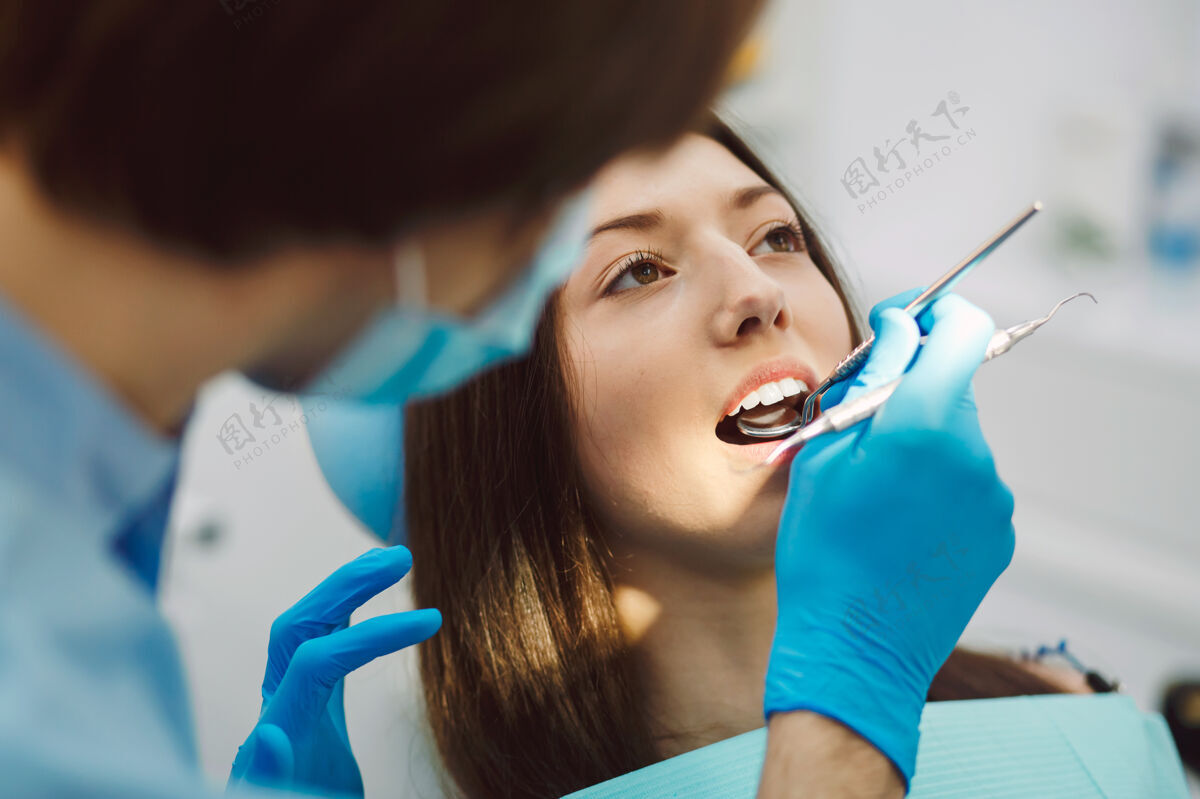 外科用镜子检查女人的牙齿成人牙科牙齿