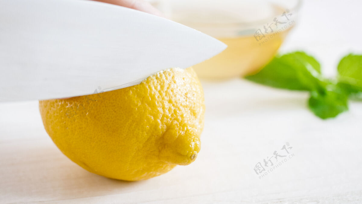 块用锋利的小刀在白色上切熟柠檬厨房自然生的