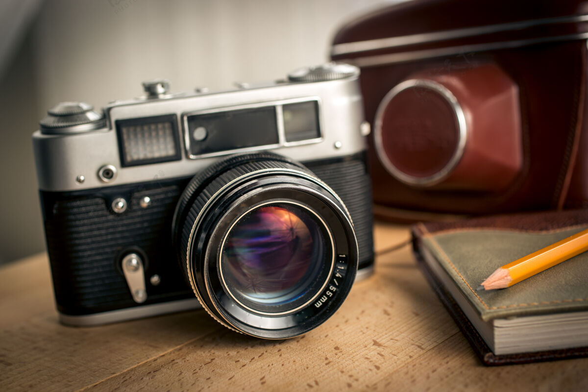 装备木桌上的经典胶卷相机和笔记本的特写镜头记者城市古董