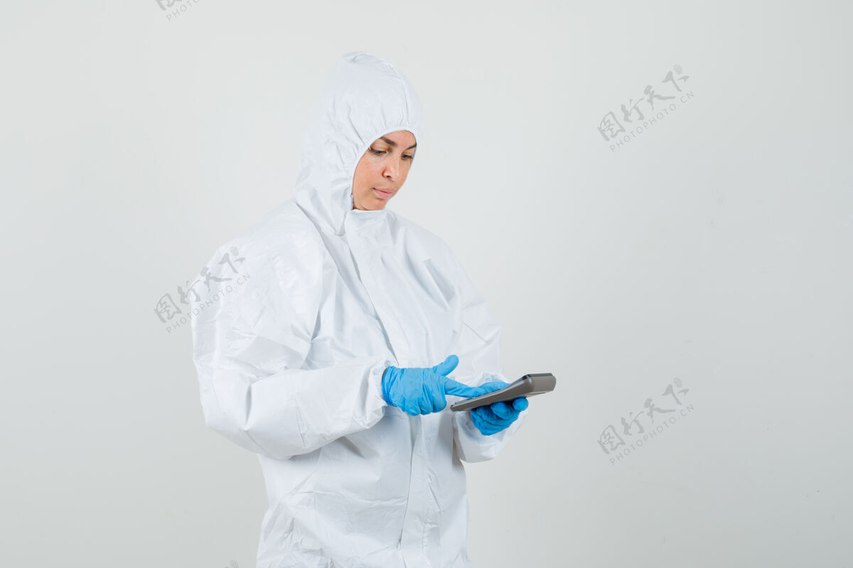 医生女医生穿着防护服在计算器上做计算成人医疗诊所