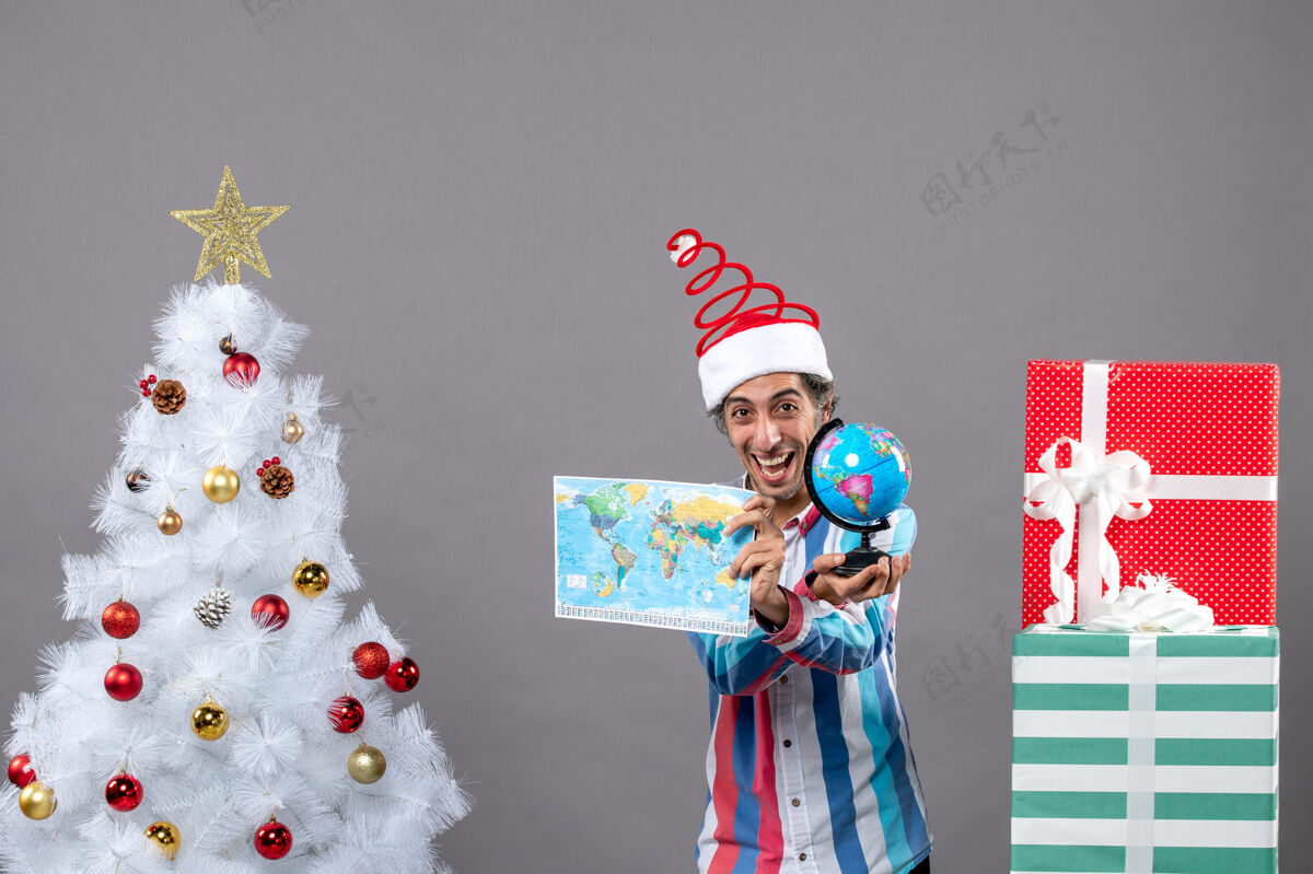 假期前视图快乐的人显示世界地图和地球仪圣诞节展示男人