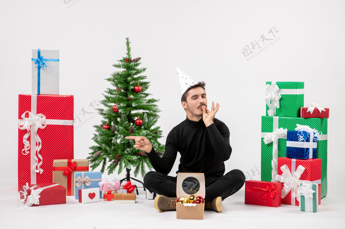 礼物年轻人围坐在白色墙上的节日礼物的正面视图人礼物庆祝