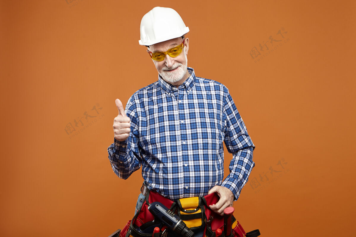 竖起大拇指摄影棚图片开朗快乐的老年人胡子修戴头盔老人竖起大拇指