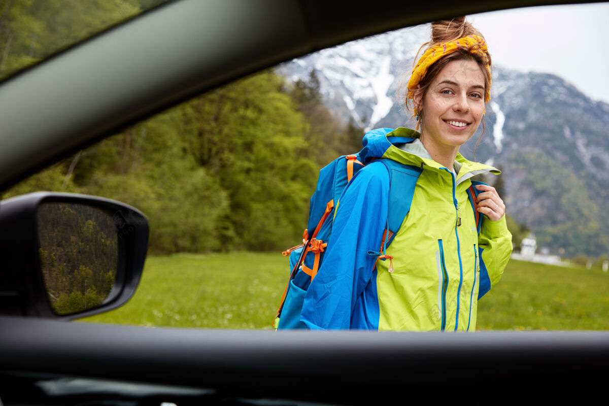 积极从车窗望去 快乐的女登山者站在户外 映衬着美丽的山景满意无忧无虑休闲