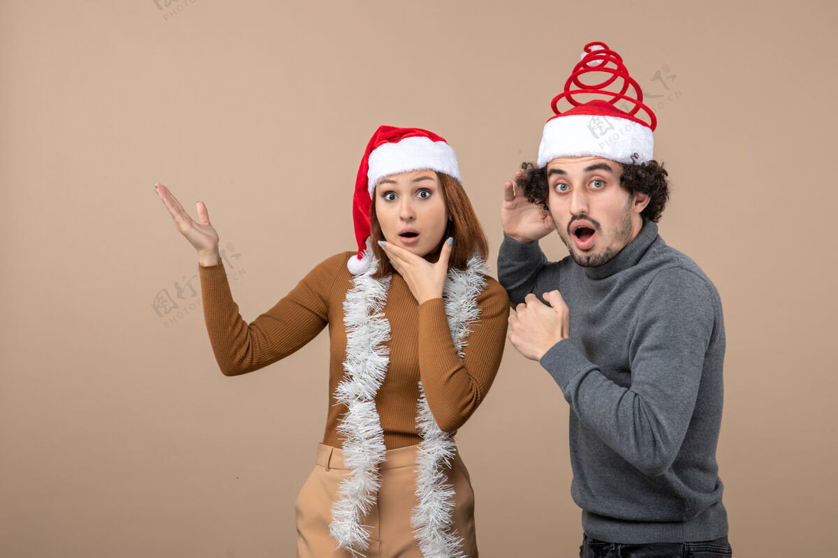 心情圣诞节心情激动满意震惊酷酷情侣戴着红色圣诞老人帽指着上方满意酷情侣红色
