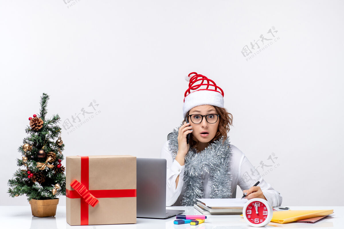 正面正面图：假日工作的年轻女性在白色背景下打电话年轻笔记本电脑年轻女性