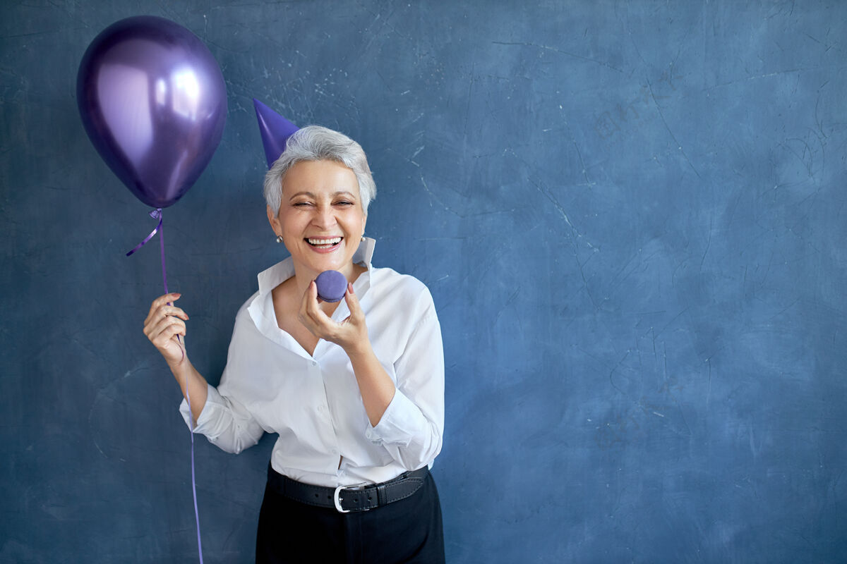 积极快乐 欢乐 休闲 娱乐的理念美丽无忧无虑的退休白发女士享受生日聚会的画像活动气球老年人