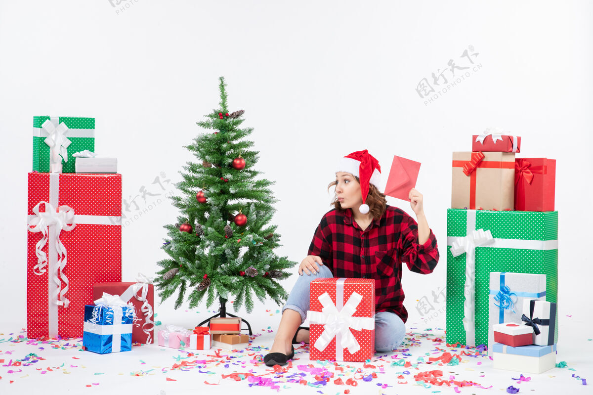 雪前视图年轻女子围坐在一个白色的墙上拿着信封的礼物冬天节日节日