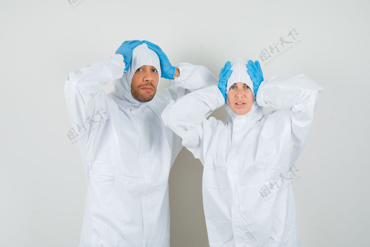 医疗保健两个医生穿着防护服双手抱着头套装人会议