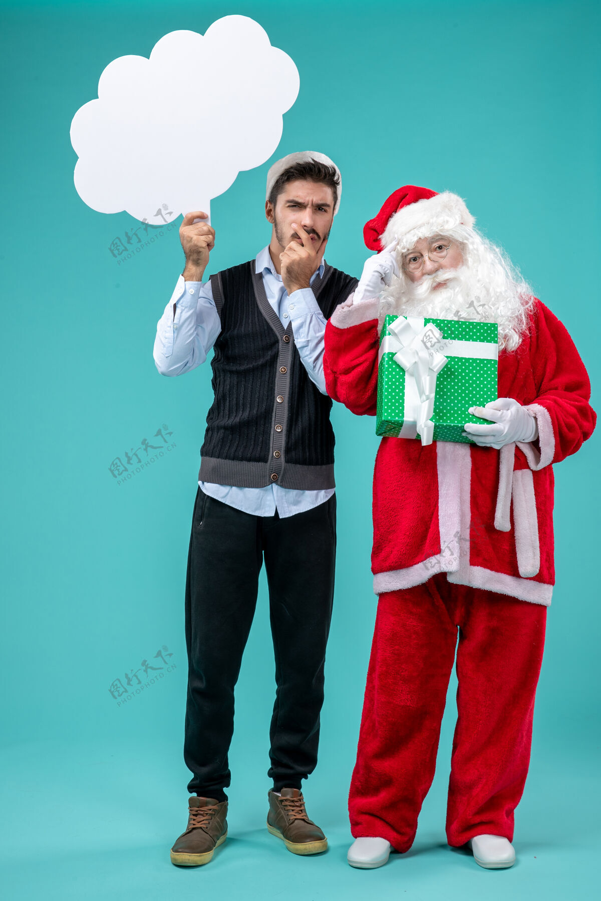 桌子前视图圣诞老人和年轻的男性谁持有白云标志蓝色的桌子上圣诞老人圣诞老人视图
