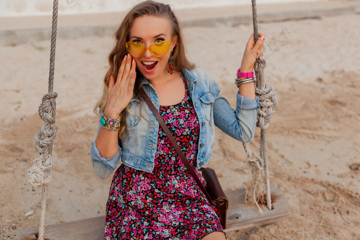 人时尚的女人在夏日的沙滩上穿着度假装 在五颜六色的黄色阳光下微笑着快乐乐趣年轻人