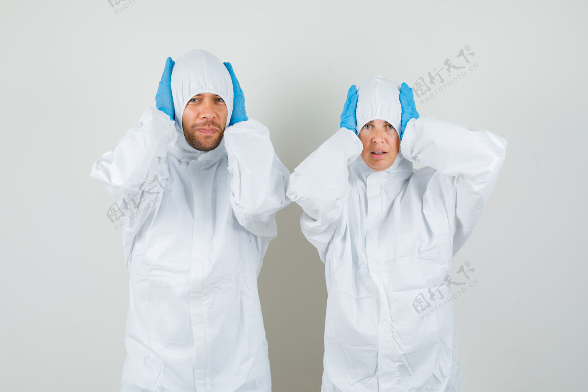 健康两个医生穿着防护服 戴着手套 双手抱着头 看上去很困惑年轻医院技术