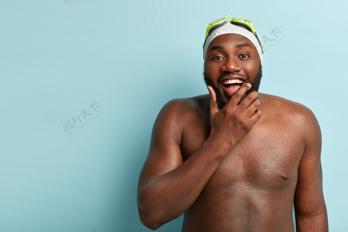 牙齿皮肤黝黑的快乐赤膊男 喜欢游泳 娱乐和健身 抱着下巴 积极凝视肌肉射击下巴