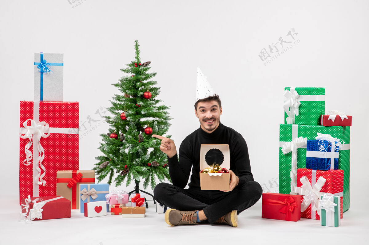 圣诞快乐年轻人围坐在白墙上的礼物面前礼物礼物雪