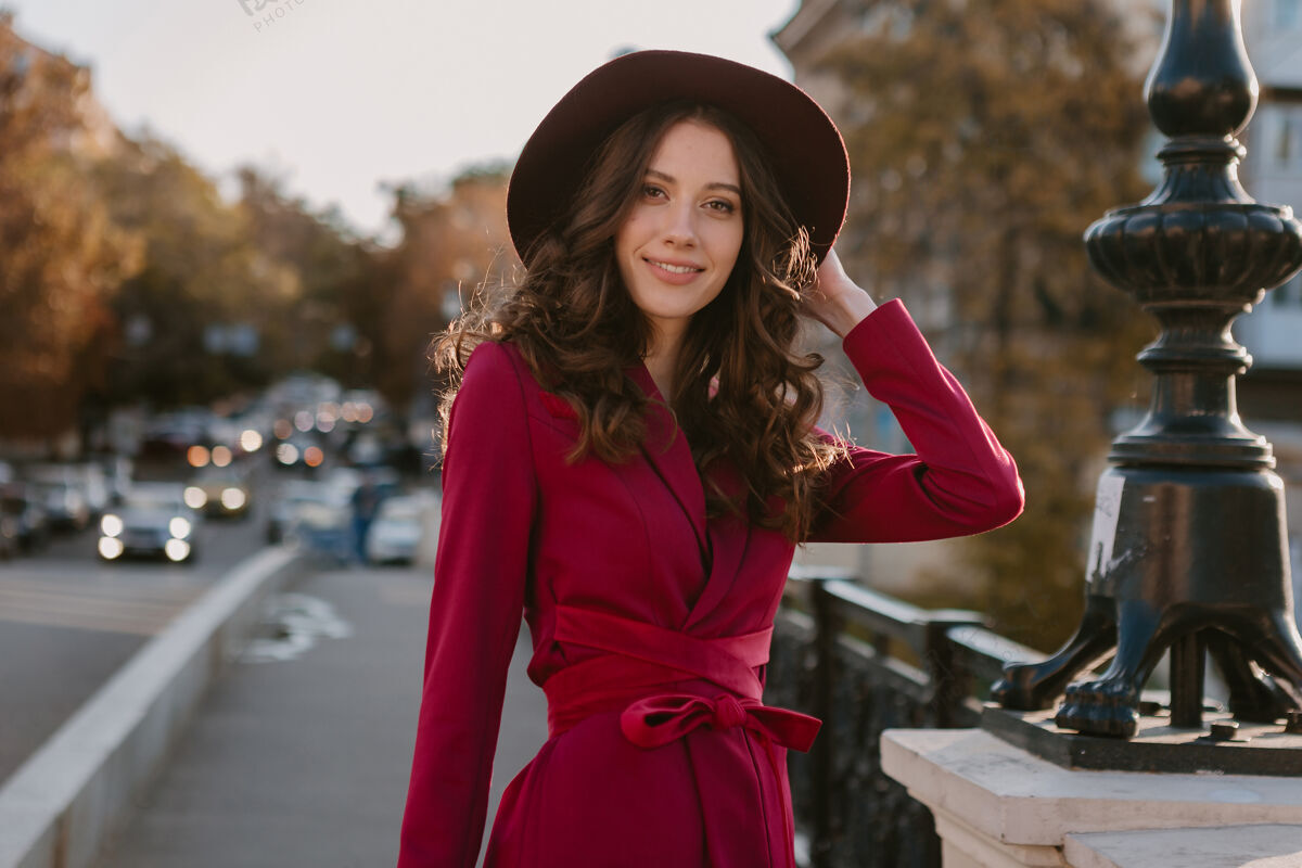 户外靓丽时尚的紫衣女人走在城市街头 春夏秋冬时节时尚潮流戴着帽子 手拿钱包女孩年轻漂亮
