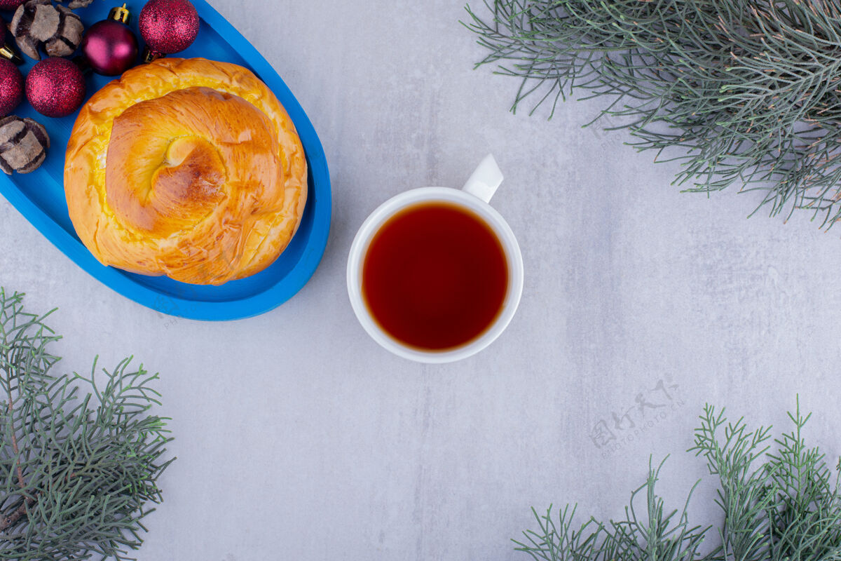 茶一盘蓝色的甜面包和圣诞装饰品 白色背景上有一杯茶冲泡热的拼盘